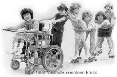 A girl in a motorized wheelchair towing five children behind her